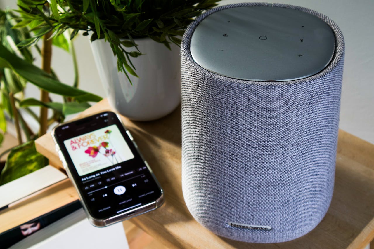 Bluetooth speaker and smartphone playing music on a table indoors.